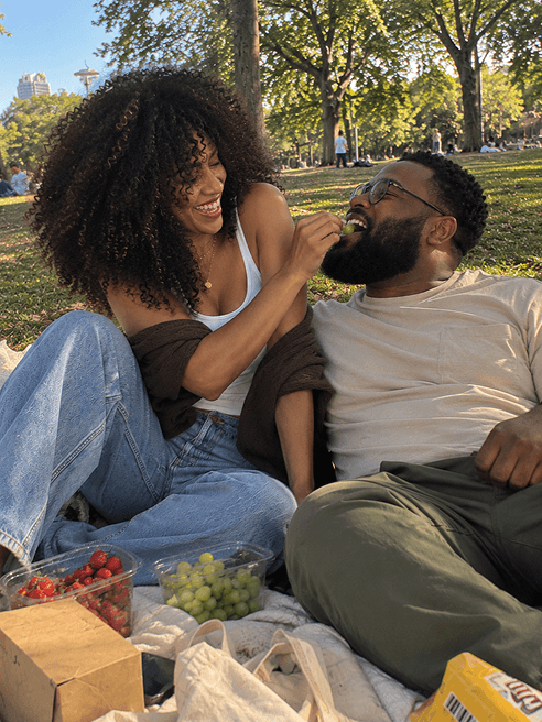 A couple enjoying a picnic together outdoors